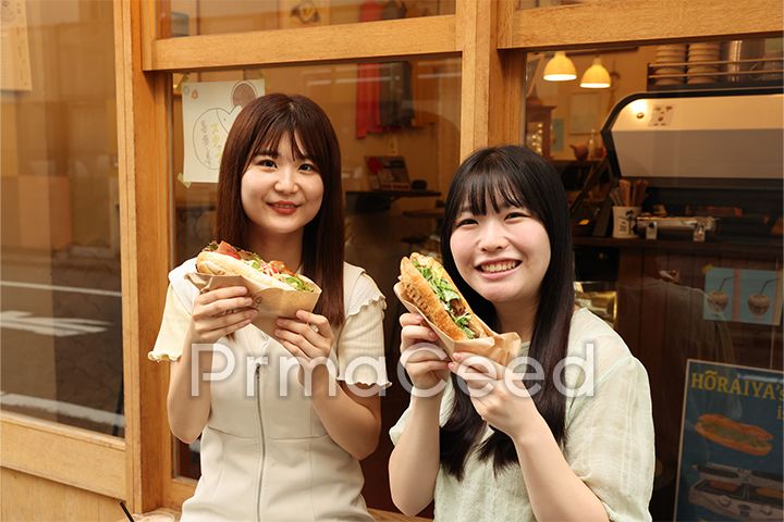 おいしいサンドウィッチを食べる社員